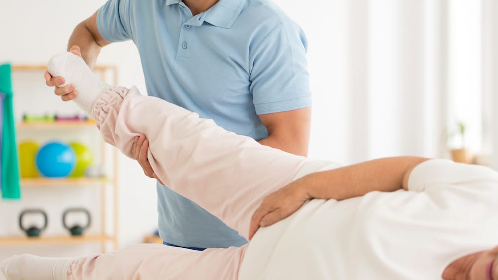 Physical Therapist working on a patients leg.