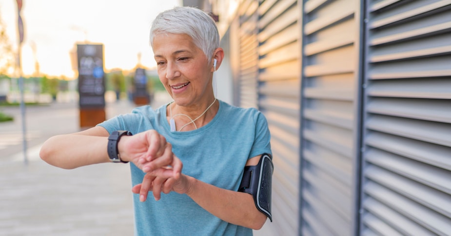 Mature Runner Checking Smart Watch. Checking Fitness Statistics On Smart Watch. Athletic mature woman monitoring her running performance on smartwatch