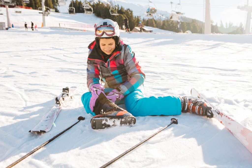 Skier injured on the slope holding knee