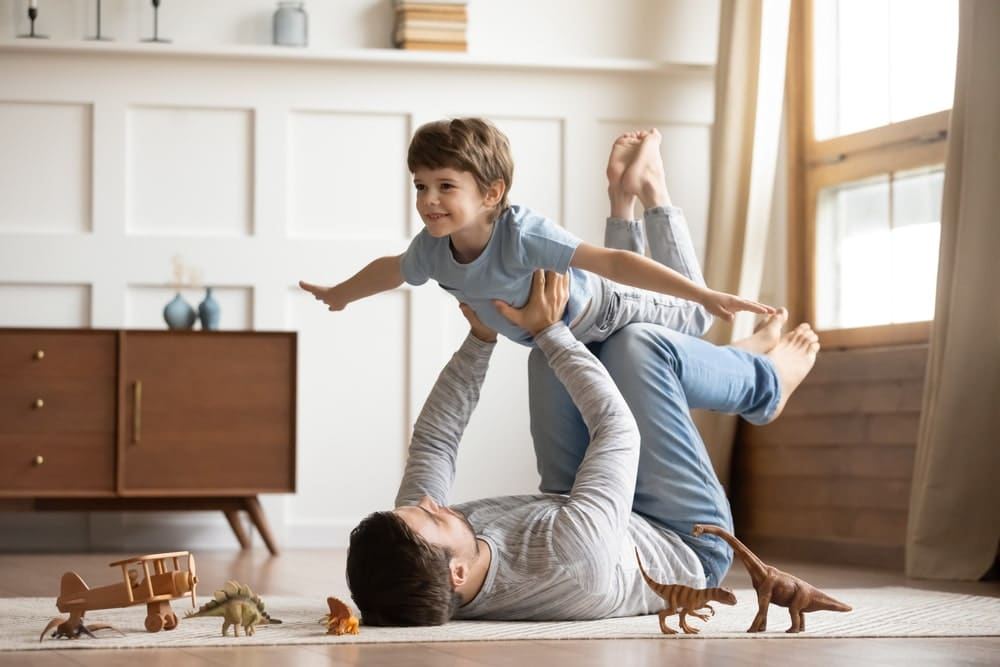 Dad lifting son up in living room