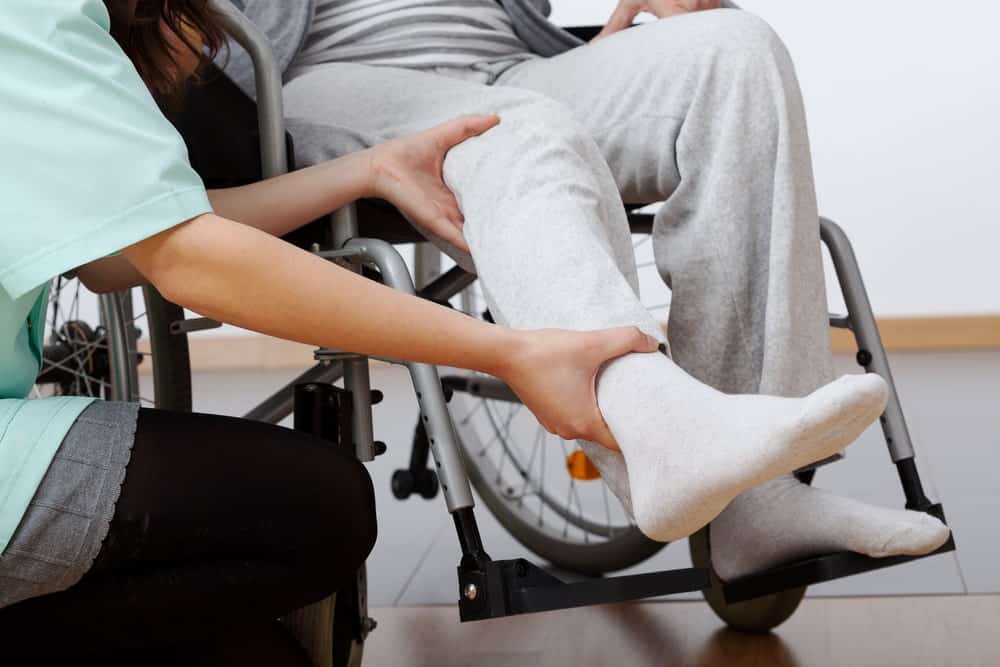 Man in wheelchair doing physical therapy stretching