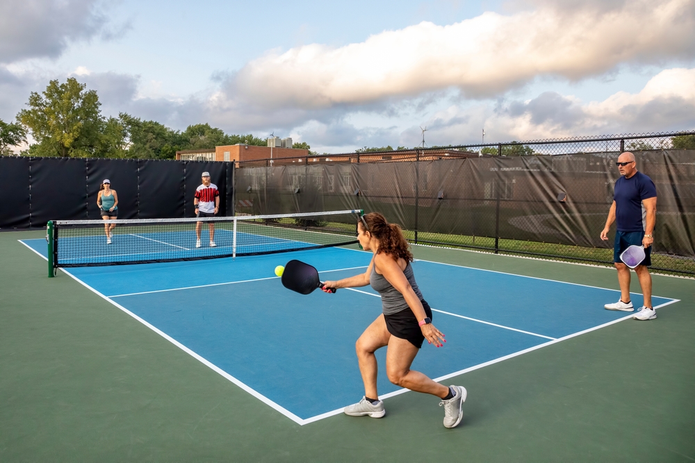 Four people playing pickleball on court