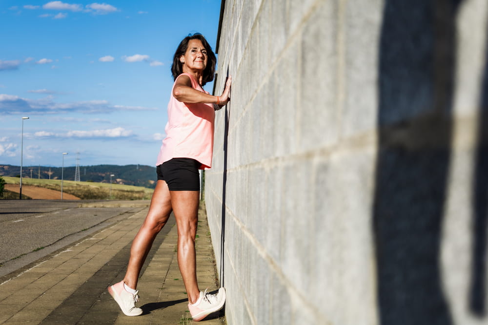 Runner stretching achilles on wall
